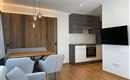 Eine moderne Wohnküche mit Holzdetails. Der Raum ist hell und einladend, mit einer gemütlichen Sitzecke.