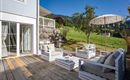 Einzigartige große Holz-Terrasse mit unverbautem Ausblick in die umliegende Berglandschaft. Moderne Terrassenmöbel, die zum Entspannen einladen und den ganzen Tag Sonne bieten. Ein moderner Gasgriller der Marke Napoleon steht für entspannte Grillabende bereit.