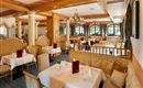 Ein elegantes Restaurant mit Holzverkleidung und stilvollen Tischen. Die Tische sind schön gedeckt und bieten eine gemütliche Atmosphäre.