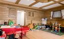 An inviting playroom with wooden paneling. There are toys and furniture in bright colors for children.