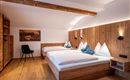 Een moderne kamer met houten details en gezellige bedden. De ontspannen sfeer nodigt uit om te blijven hangen.