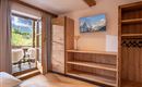 Een moderne kamer met houten planken en een tv. Door de open deuren ziet men een prachtig uitzicht op de bergen.