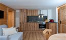 A modern kitchen with wooden cabinets and stainless steel appliances. The room is bright and offers a cozy atmosphere.