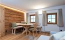 A cozy dining area with wood paneling and large windows. The room is bright and inviting, perfect for social hours.