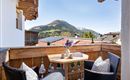 Ein schöner Balkon mit Blick auf die Berge. Ein Tisch mit Kaffeetassen und gemütlichen Stühlen lädt zum Entspannen ein.