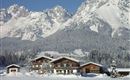 A picturesque alpine landscape with snow-covered mountains in the background. In front stands a cozy wooden house, surrounded by smooth, white snow.