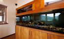 Großes, in die maßgefertigte Holzeinrichtung integriertes Aquarium im Wohnbereich.