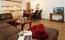 A cozy, modern living room with a comfortable couch and a dining area.
