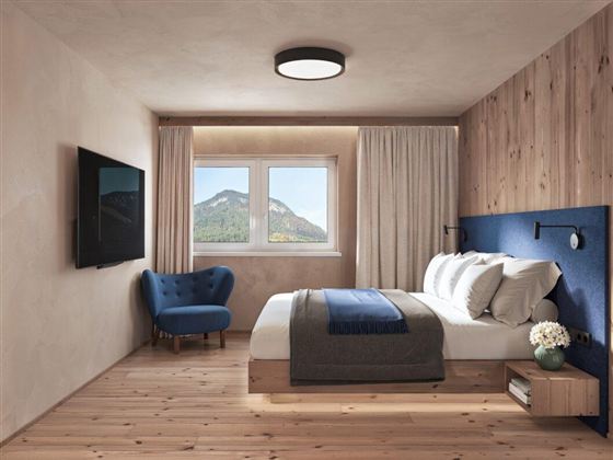 Ein modernes Schlafzimmer mit einem gemütlichen Bett und eleganten Holzdetails. Durch das Fenster ist eine malerische Berglandschaft sichtbar.