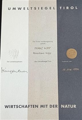 A certificate titled "Environmental Seal of Tyrol". It displays the name of a house and the date of issue.