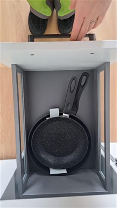 Eine moderne Küchenaufbewahrung mit einer Pfanne und zwei Pfannenwendern. Die Ansicht ist von oben, und die utentilien sind ordentlich angeordnet.