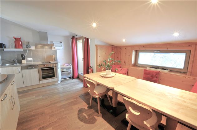 A modern kitchen with a large dining area. Bright colors and cozy furniture create an inviting atmosphere.