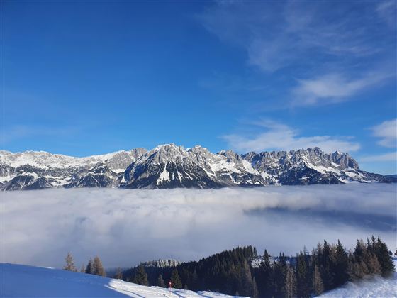 Eine beeindruckende Berglandschaft, unter dem Wilden Kaiser liegt eine schimmernde Wolkendecke.