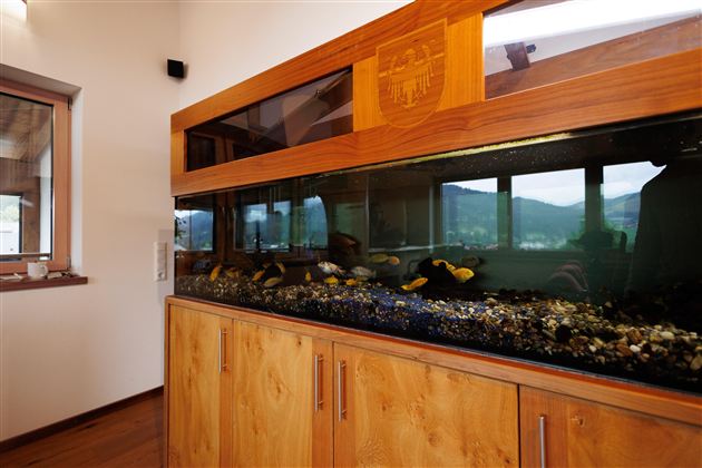 Großes, in die maßgefertigte Holzeinrichtung integriertes Aquarium im Wohnbereich.