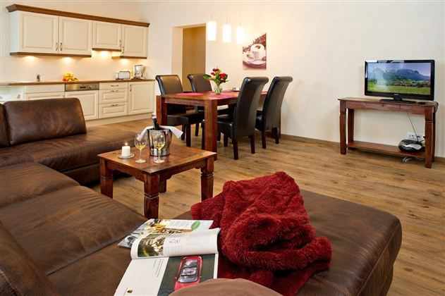A cozy, modern living room with a comfortable couch and a dining area.